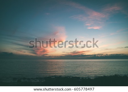 sunset over the calm lake beach with dramatic colorful sky and tree silhouettes - vintage green retro effect