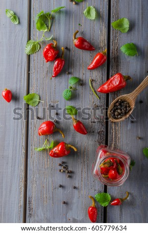 Fresh chilli pepper in bowl with herbs