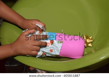 Young child's hands unwrapping a gift
