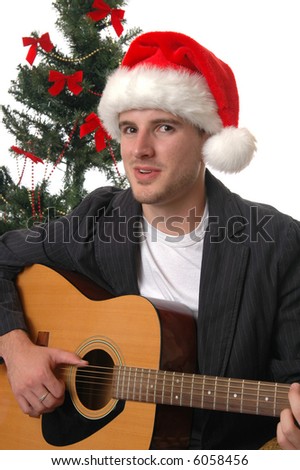 A young man in a Santa hat playing the guitar and singing Christmas Carols