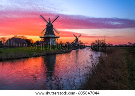 The famous twin mills of Greetsiel, East Frisia at sunrise Royalty-Free Stock Photo #605847044