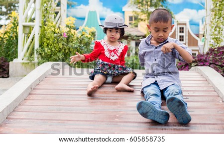 Boys and girls are playing happily on a wooden bridge