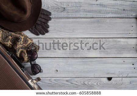 Man's hat and retro accessories for travel on a white painted wooden surface