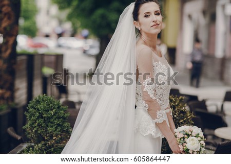 bride standing at a table with a bouquet of flowers