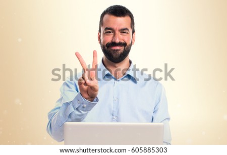 Man with laptop counting two on ocher background
