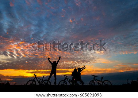 Family cyclist and Bicycle silhouettes on the dark background of sunsets.