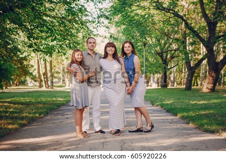 mom dad and two daughters on nature in summer park