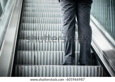 A Man on a moving escalator.
