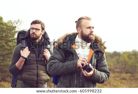 Two bearded men hiking in swamps and taking pictures. Camp, adventure, trip and traveling concept.