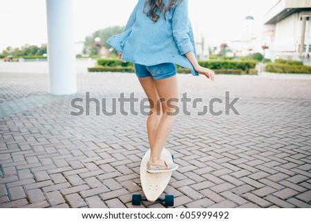 Beautiful young girl with longboard in sunny weather outdoors. Healthy lifestyle, sport
