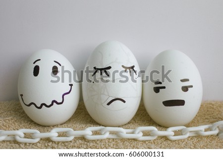 Eggs are funny with faces. Concept: pain. White chain. Photo for your design on a white background