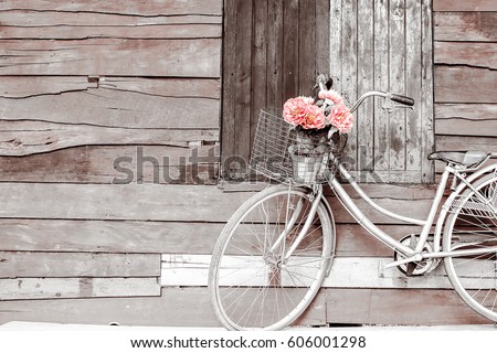 Bicycles old vintage flowers in a basket. Parked on the sidewall of the wooden house ideal for design work Classic hoodie style