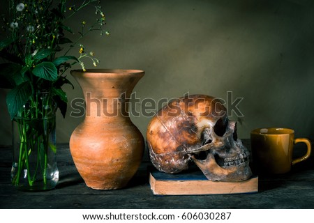 Human skull and flower vase on wooden table background, Still life concept
