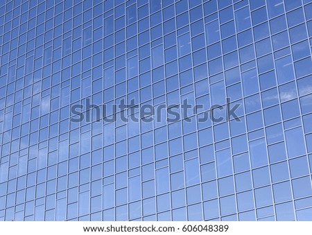 modern glass facade of office building reflects clouds and blue sky