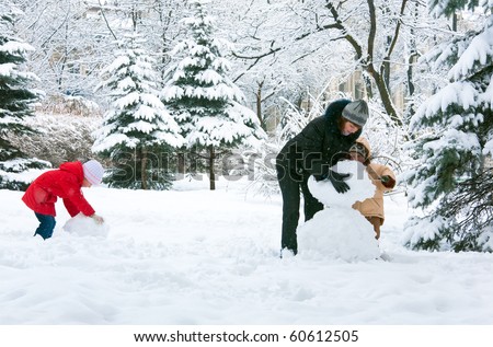 Happy family (mother with small boy and girl) in winter city park