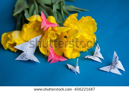 bouquet of yellow tulips closeup on a blue  background with butterflies