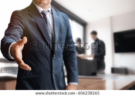 Businessman Offering Handshake in meeting room.
