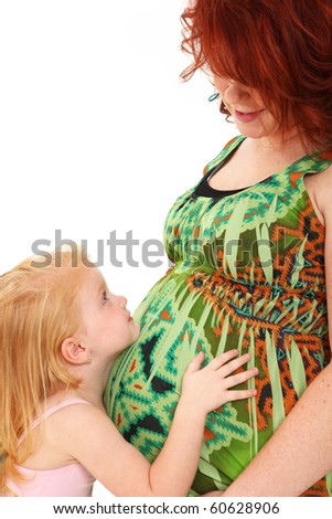 Adorable mother daughter picture with daughter hugging mom's pregnant belly over white background.