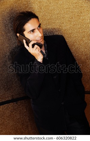 Young man dressed in suit, using mobile phone