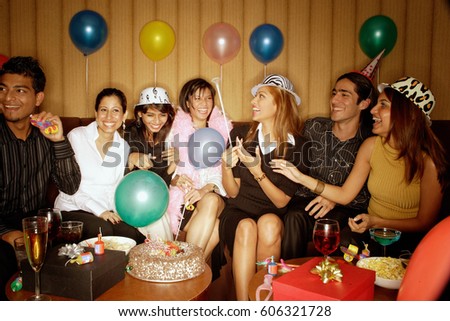 Young adults sitting side by side, celebrating