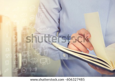 woman hand opening book paper on blurry building and icon symbol.