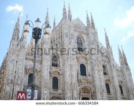 Duomo di Milano cathedral in downtown Milan, Italy. View from town square with street lantern and metro red sign on sunny summer day with nobody. Travel tourism concept clear bright sky background.