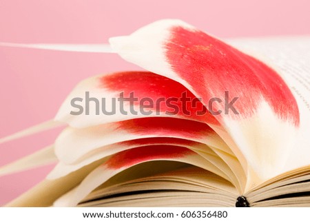 education and reading concept - open book with flower leafs, pink background
