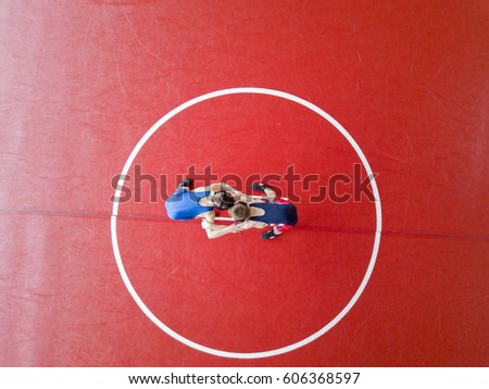 Youth wrestlers hand fighting on the mat. View from above.