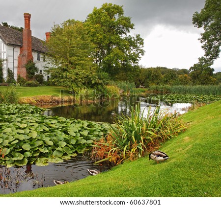 Medieval Moated English Manor and garden with Ducks Royalty-Free Stock Photo #60637801