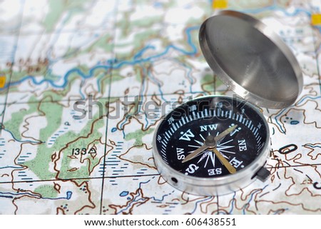 Journey into the world of adventure. Topographic map and compass on it.