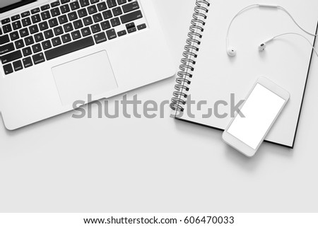 Laptop, phone, notebook and earphones on white background