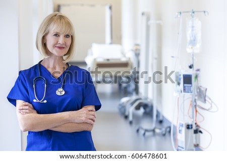 Blonde European Caucasian female surgical nursing staff wearing uniform scrubs in hospital corridor
