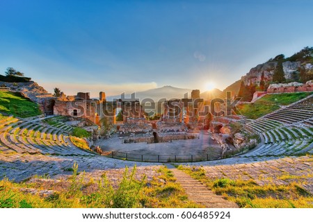 Ancient theatre of Taormina Siciliy Italy  with Etna erupting volcano at sunset Royalty-Free Stock Photo #606485924