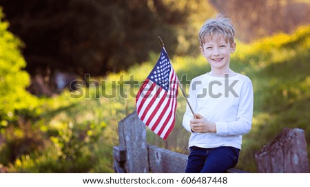cheerful smiling little boy holding american flag celebrating 4th of july