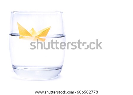 Paper boat in a glass of water isolated