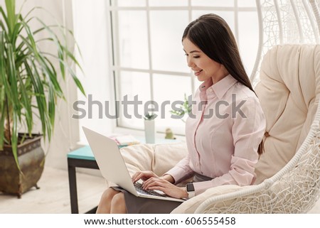 Attentive young female laboring on notebook computer
