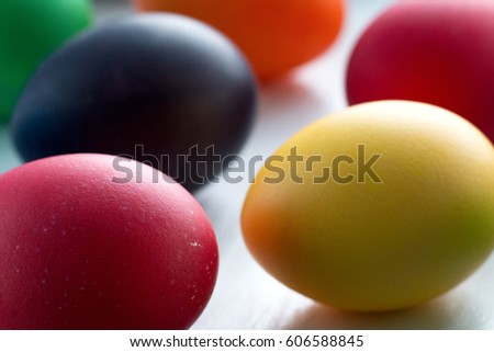 Colorful Easter eggs close-up macro on a white wooden table. The concept of a holiday and a happy Easter.