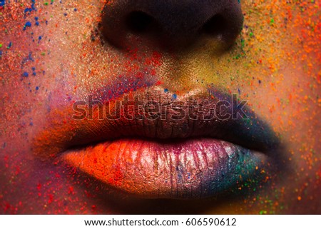 Crop of female lips with colorful make up. Beautiful fashion model with creative art makeup. Abstract colourful splash make-up. Holi festival