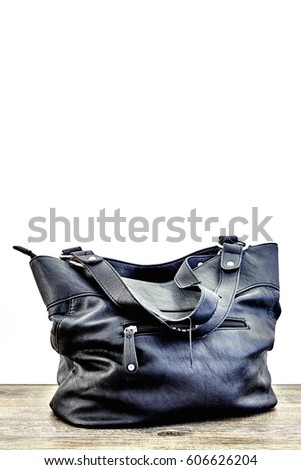 A studio photo of a ladies black hand bag