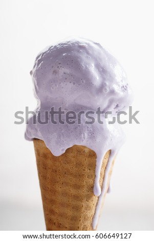 melting purple color ice cream on waffle cone