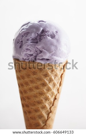 melting purple color ice cream on waffle cone