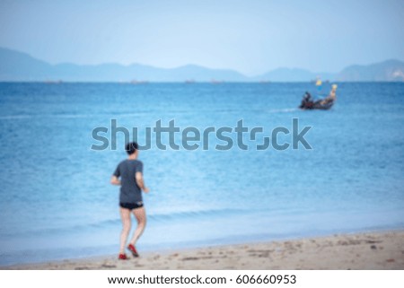 man exercise runner on the beach with blue sea background in morning. Blur photo