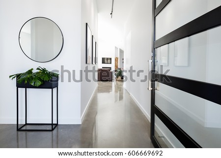 Contemporary home entry hall with polished concrete floors Royalty-Free Stock Photo #606669692