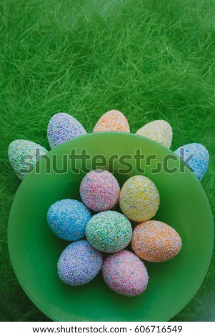 Easter eggs on a green background in a nest of artificial grass