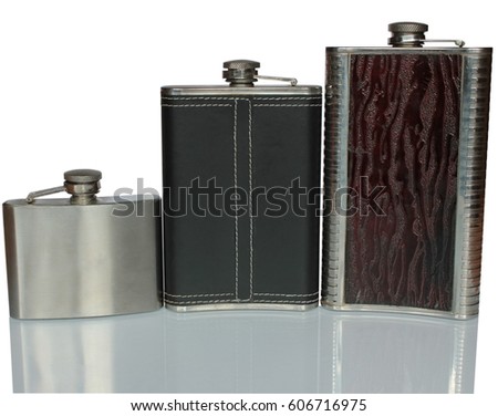 Three flat flask for alcohol on a glass table isolated on white