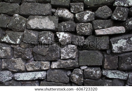 Old stone wall background or wallpaper. Rough grey stone bricks design. Masonry wall made of big rocks. Rustic stones texture. Stone brickwork photo. Solid protection, safety or durability concept 