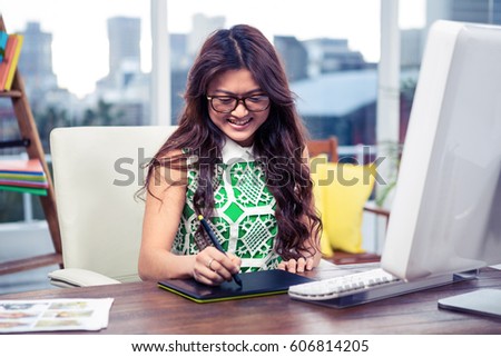 Smiling creative businesswoman using digital board in the office
