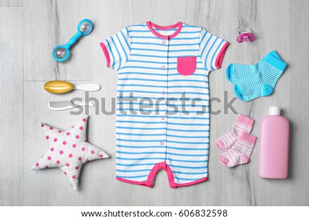Baby clothes and accessories on wooden background