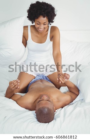Happy couple playing on the bed at home