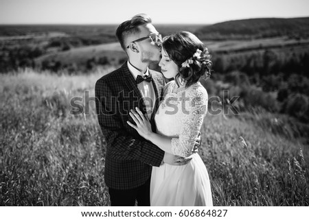 Young couple in love, groom and bride in wedding dress kissing at the nature. Wedding. Wedding day. Bridal bouquet. Black and white.